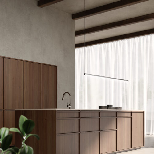 alt="corner view of island and talls with Kyoto walnut paneling and solid wood handles"